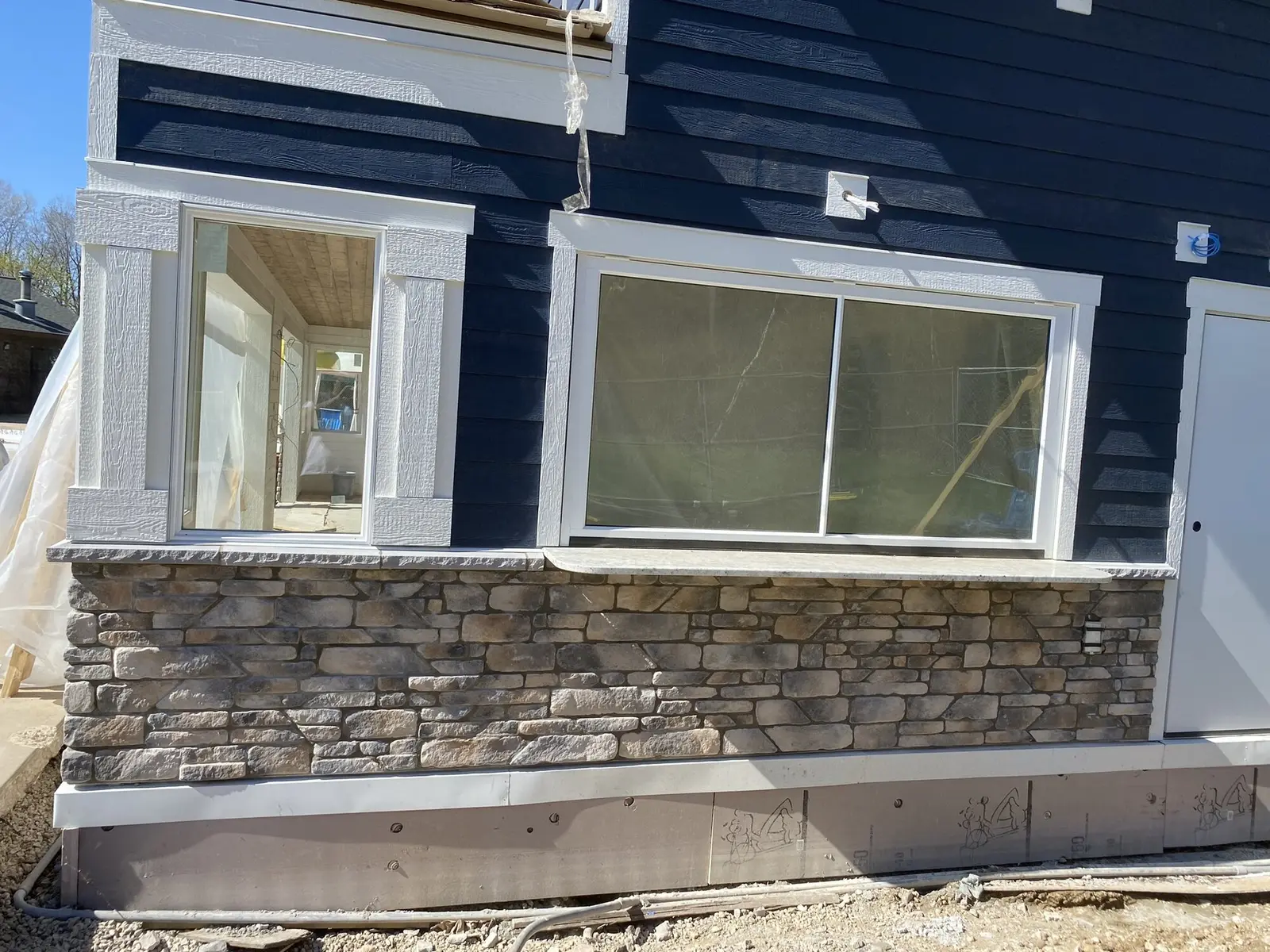 Finished stone veneer wainscot detail on custom home exterior