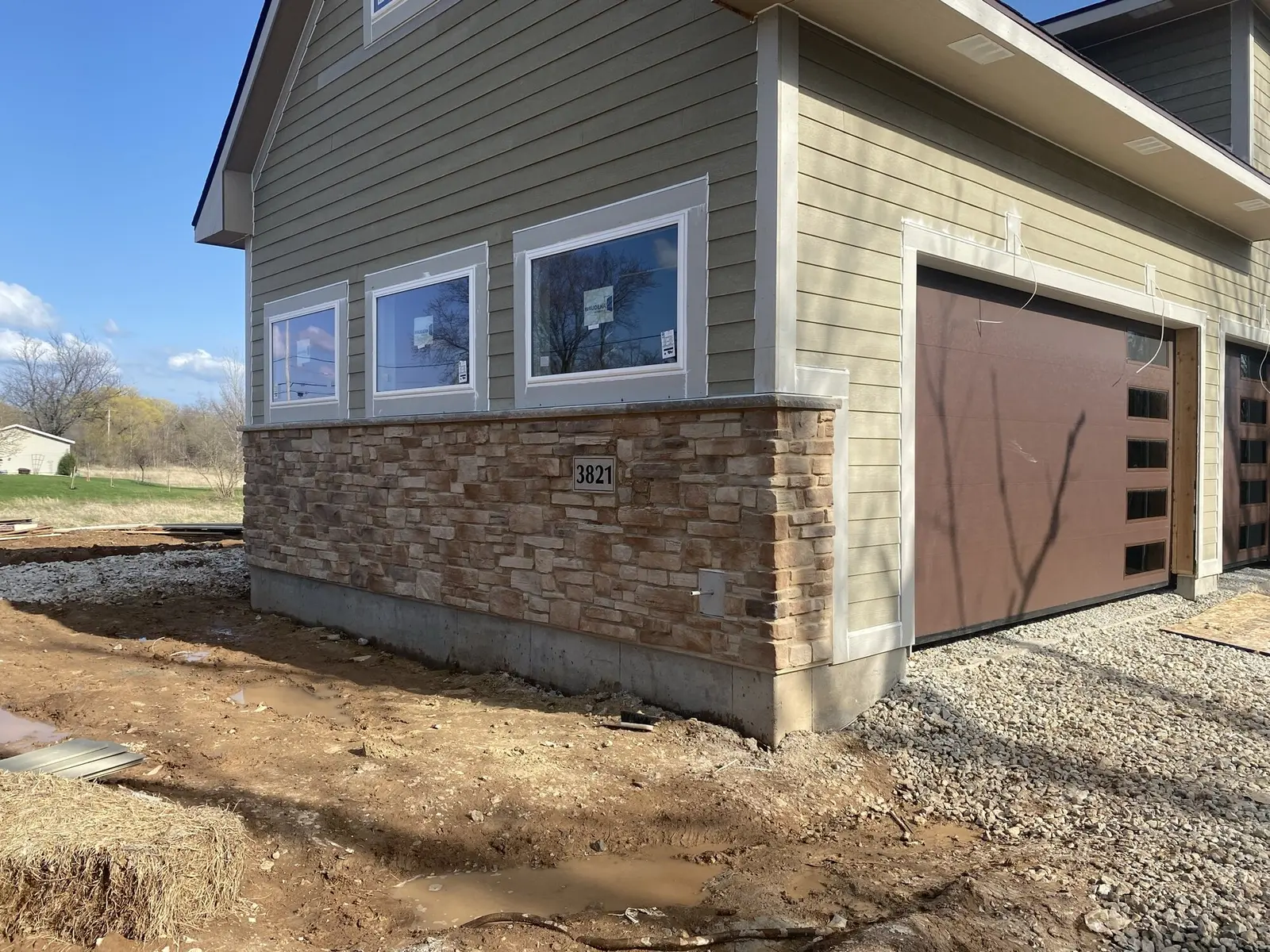 Stone veneer wainscot on custom home exterior