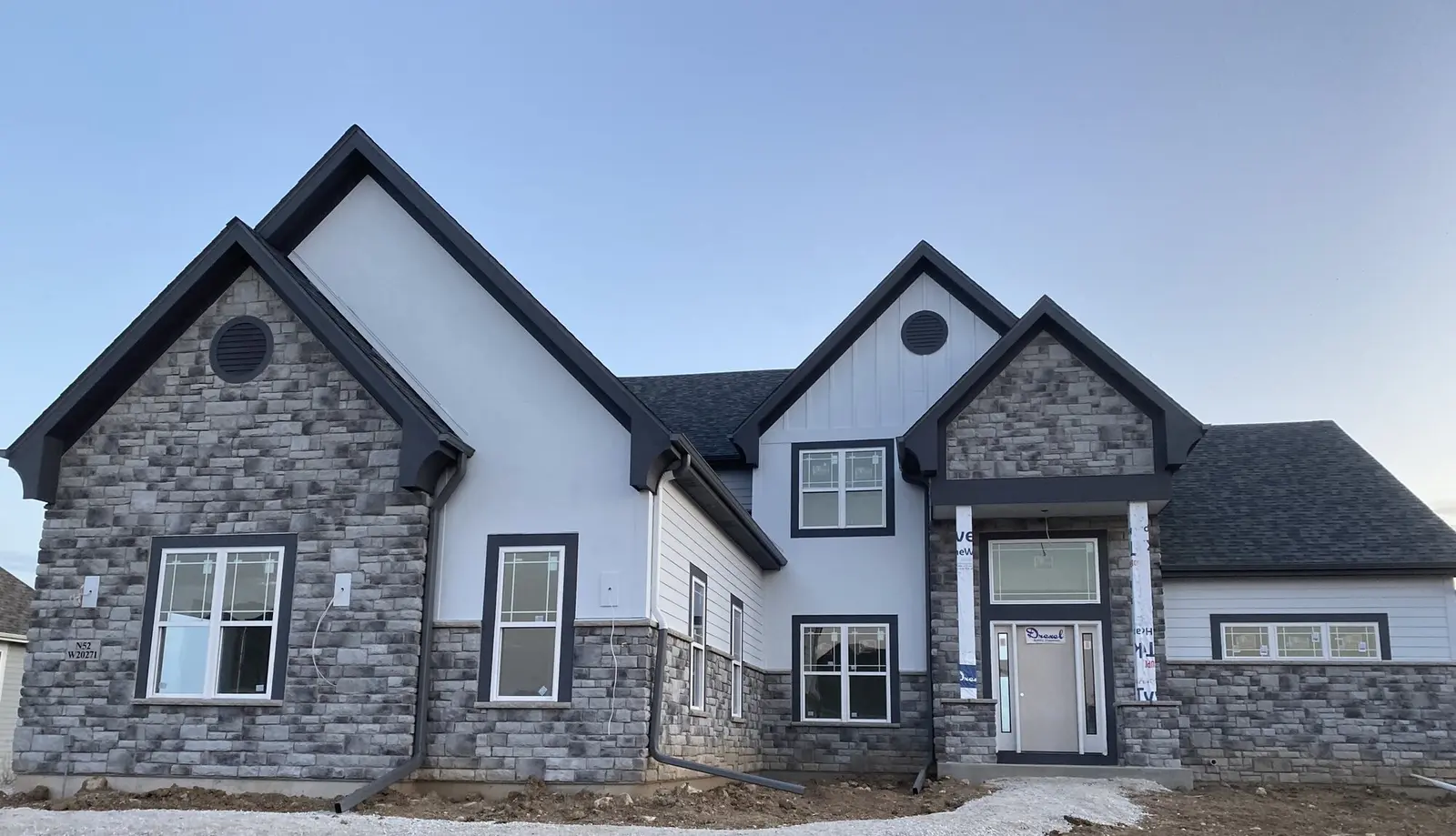 Custom home with manufactured stone veneer exterior installed by Legacy Masonry